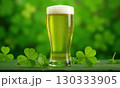Glass of green foamy irish beer stands on green grassy clover background. St. Patrick Day 130333905