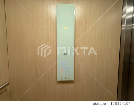 Modern elevator panel with illuminated floor buttons on wooden wall interior. Technology, transport and housing infrastructure representing service, digital system and contemporary design. 130334104