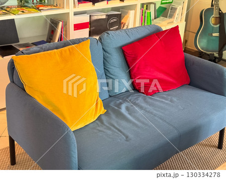 Cozy sofa with colorful pillows in reading lounge. Interior design, relaxation and creative lifestyle corner. Cozy sofa with colorful pillows in reading lounge. Interior design, relaxation and creative lifestyle corner. 130334278