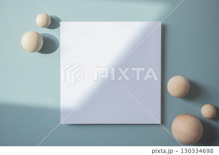 Empty white blank greeting or invitation card with wooden ball on blue background. Mock up presentation. 130334698