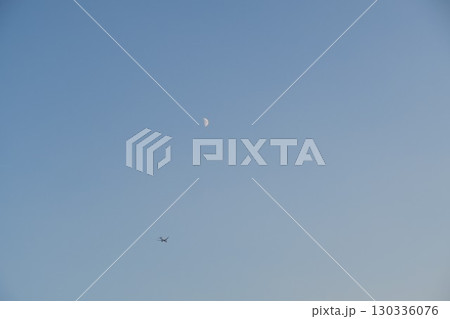 上弦の月の下を飛ぶ飛行機を浮間公園で撮影 130336076