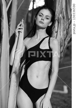Elegant Woman in One Piece Swimsuit Leaning Against Tree in Charming Black and White Photo Elegant Woman in One Piece Swimsuit Leaning Against Tree in Charming Black and White Photo 130336590