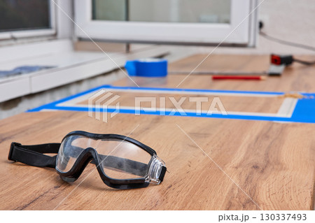 protective glasses lying on kitchen countertops, marking cutting hole for the sink, renovation, copy space 130337493