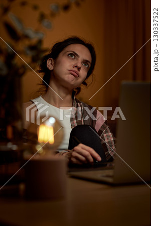 beautiful graphic designer woman working at home office remotely using digital graphic tablet and laptop in the evening 130337522