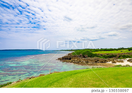 爽やかな南国の青空とサンゴが映える海が見えるリゾートゴルフ場の海越えホール（沖縄県宮古島市） 130338097