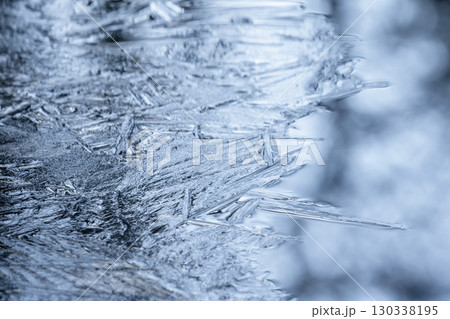 Close-up view of intricate ice patterns with frosty blue coloration, 130338195