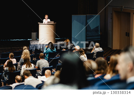 Female speaker giving a talk on corporate business conference. Unrecognizable people in audience at conference hall. Business and Entrepreneurship event Female speaker giving a talk on corporate business conference. Unrecognizable people in audience at conference hall. Business and Entrepreneurship event 130338314