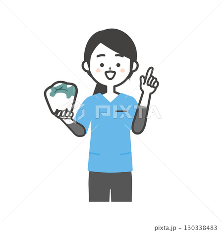 詰め物をした奥歯をもって指を立てるスクラブ姿の女性 130338483