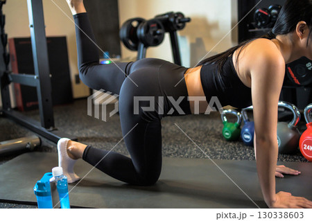 バックキックでお尻を鍛えるかっこいい女性 筋トレ女子 ヒップアップ スポーツジム バックキックでお尻を鍛えるかっこいい女性 筋トレ女子 ヒップアップ スポーツジム 130338603