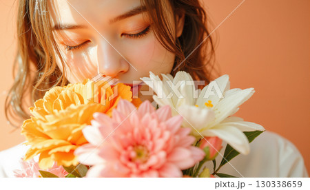 花束を抱える若い女性・プレゼントや記念日の贈り物イメージ 130338659