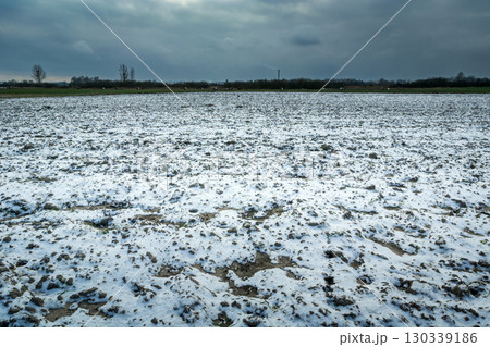 Cloudy sky over a snow-covered plowed field 130339186