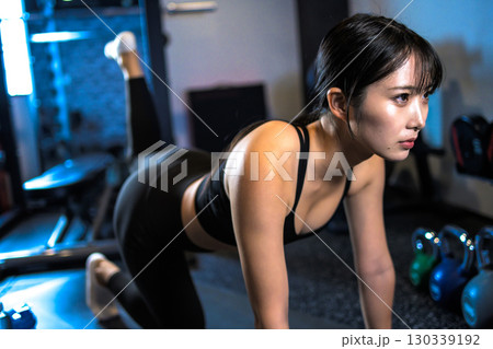 バックキックでお尻を鍛えるかっこいい女性 筋トレ女子 ヒップアップ スポーツジム バックキックでお尻を鍛えるかっこいい女性 筋トレ女子 ヒップアップ スポーツジム 130339192