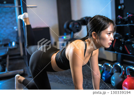 バックキックでお尻を鍛えるかっこいい女性 筋トレ女子 ヒップアップ スポーツジム バックキックでお尻を鍛えるかっこいい女性 筋トレ女子 ヒップアップ スポーツジム 130339194