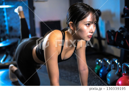バックキックでお尻を鍛えるかっこいい女性 筋トレ女子 ヒップアップ スポーツジム バックキックでお尻を鍛えるかっこいい女性 筋トレ女子 ヒップアップ スポーツジム 130339195