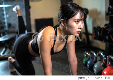 バックキックでお尻を鍛えるかっこいい女性 筋トレ女子 ヒップアップ スポーツジム バックキックでお尻を鍛えるかっこいい女性 筋トレ女子 ヒップアップ スポーツジム 130339196