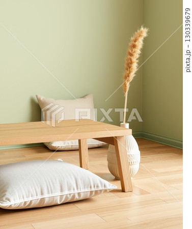 Low table, pillows, and vase adorn a light green wall, creating a peaceful interior scene. 130339679