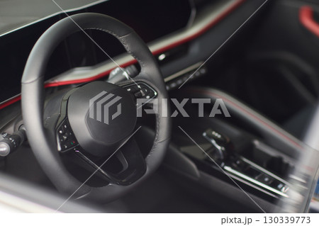 Closeup of a modern car steering wheel with control buttons for technology and convenience 130339773