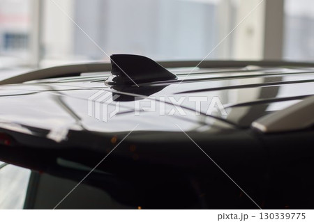 A detailed closeup view of the Car Roof Antenna positioned on a sleek, dark vehicle 130339775