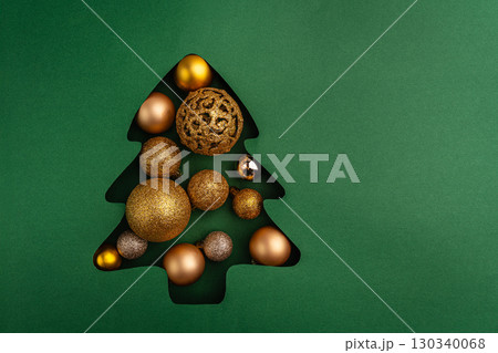 Gold Christmas Ornaments in Tree-Shaped Paper Cutout Gold Christmas Ornaments in Tree-Shaped Paper Cutout 130340068