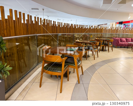 Wooden tables and chairs in a cafe. Dining, interior seating, and hospitality design. 130340975