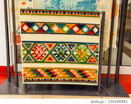 Colorful decorative carpet with geometric patterns. Home decor, traditional design and textile craftsmanship with vibrant colors. 130340981