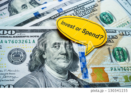 Money with the words invest or spend. Financial decision making. 130341155