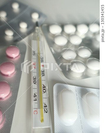 Close-Up of Pills and Thermometer on White Background for Healthcare Concept Close-Up of Pills and Thermometer on White Background for Healthcare Concept 130341455