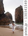 In Solitude by the Ocean A Woman Walking Alone Peacefully on the Beautiful Scenic Beachside 130341549