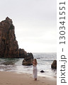 In Solitude by the Ocean A Woman Walking Alone Peacefully on the Beautiful Scenic Beachside 130341551