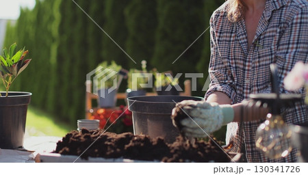 Preparation for transplanting a houseplant using extended clay, soil, shovel, rake and flowerpot. Home gardening. Hobbies and leisure concept. Preparation for transplanting a houseplant using extended clay, soil, shovel, rake and flowerpot. Home gardening. Hobbies and leisure concept. 130341726