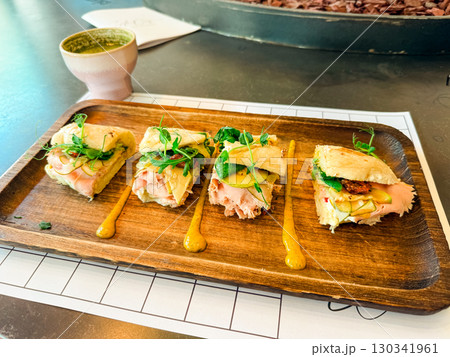 Sandwich portions with fresh vegetables on wooden tray. Culinary presentation, nutrition, and gourmet lifestyle in cafe dining experience. 130341961