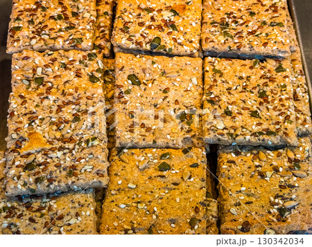 Whole grain seed crackers in square shape. Healthy nutrition, fiber and organic baked snacks. 130342034