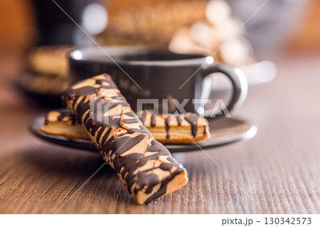 Sfogliatine glassate with chocolate. Italian crispy dessert on wooden table. Sfogliatine glassate with chocolate. Italian crispy dessert on wooden table. 130342573