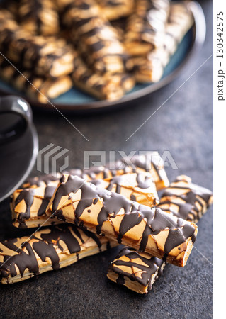 Sfogliatine glassate with chocolate. Italian crispy dessert on black table. Sfogliatine glassate with chocolate. Italian crispy dessert on black table. 130342575