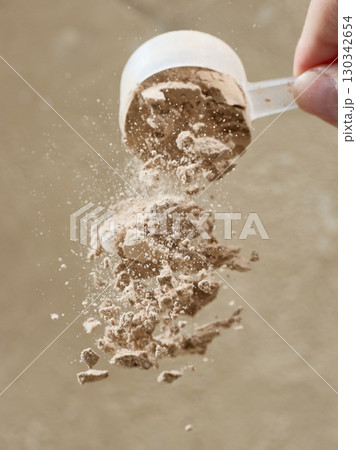 protein powder spills from measure scoop. whey sports nutrition. dry mixture protein powder spills from measure scoop. whey sports nutrition. dry mixture 130342654