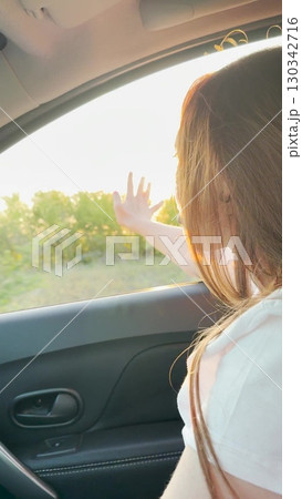 Girl watching the sunset from the car, peaceful drive through open fields, golden hair illuminated by sunlight, mindful travel experience, calming countryside scene, beautiful evening glow, quiet Girl watching the sunset from the car, peaceful drive through open fields, golden hair illuminated by sunlight, mindful travel experience, calming countryside scene, beautiful evening glow, quiet 130342716