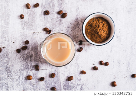 Close up of Yemeni coffee with cardamom, cinnamon and cream in a glass on table top view Close up of Yemeni coffee with cardamom, cinnamon and cream in a glass on table top view 130342753