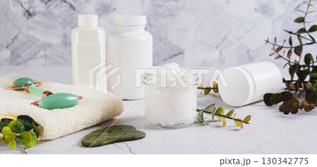 Beef tallow for skin care in a jar and massagers on the table web banner 130342775