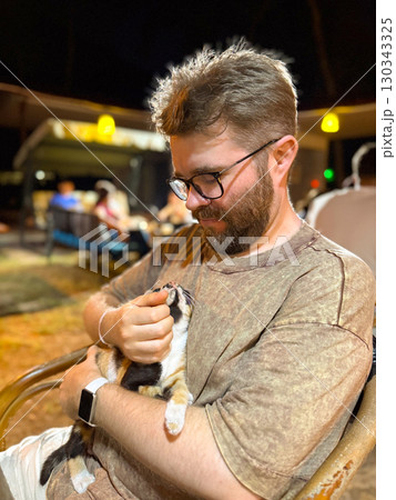 Man looking at kitten with mutual gaze in close moment. Intimacy, trust, and human animal connection with companionship, affection, and emotional bond Man looking at kitten with mutual gaze in close moment. Intimacy, trust, and human animal connection with companionship, affection, and emotional bond 130343325