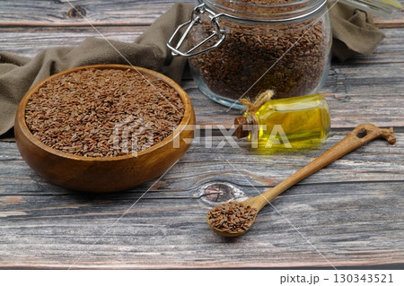 Flax seeds. Flaxseed powder in a wooden spoon. Standing on a Wooden background. 130343521