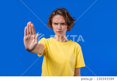Serious woman demonstrates stop forbidden gesture, assertive body language Serious woman demonstrates stop forbidden gesture, assertive body language 130343594