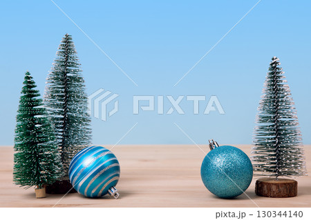 Christmas background with green tree and turquoise Christmas balls on a wooden table. Christmas and New Year design holiday card Christmas background with green tree and turquoise Christmas balls on a wooden table. Christmas and New Year design holiday card 130344140