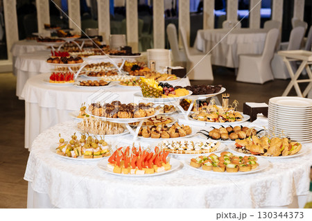 Luxurious banquet table with assorted finger foods and snacks at a formal event Luxurious banquet table with assorted finger foods and snacks at a formal event 130344373