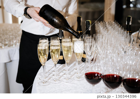 Glasses of champagne and red wine being served at a formal celebration event Glasses of champagne and red wine being served at a formal celebration event 130344396