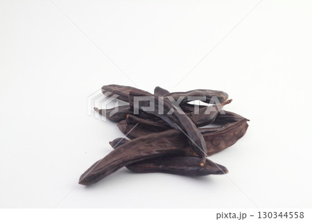 Carob on white background. Organic carob pods with seeds Carob on white background. Organic carob pods with seeds 130344558