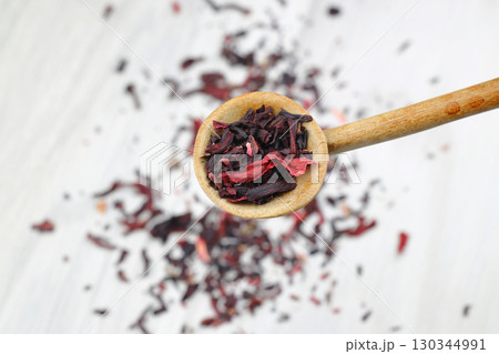 Karkade tea. Hibiscus tea leaves in wooden spoon isolated on white background. File contains clipping path. Top view. Karkade tea. Hibiscus tea leaves in wooden spoon isolated on white background. File contains clipping path. Top view. 130344991