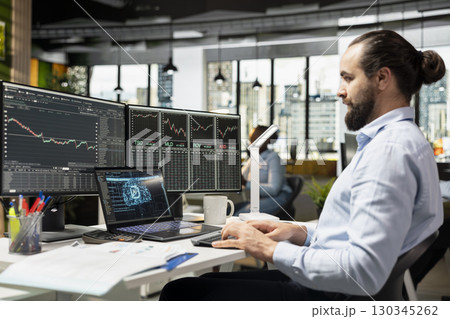 Trader running AI powered tools on laptop for automated trading and portfolio rebalancing. Man applying deep learning algorithms using notebook software to analyze complex market data Trader running AI powered tools on laptop for automated trading and portfolio rebalancing. Man applying deep learning algorithms using notebook software to analyze complex market data 130345262