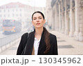 Portrait of businesswoman in black coat standing 130345962