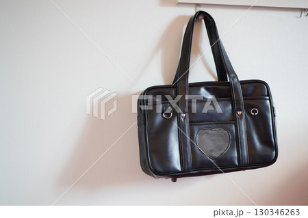 壁に掛けられた黒いスクールバッグ 学生鞄 通学に使う定番の通学バッグ 130346263