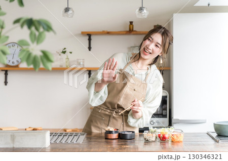 キッチンでお弁当を詰める若いアジア人女性 キッチンでお弁当を詰める若いアジア人女性 130346321